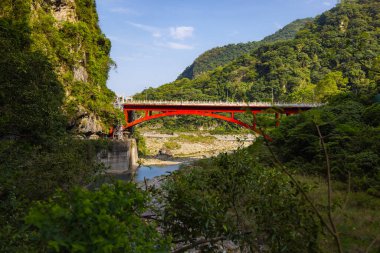 Shakadang Köprüsü, Taroko Ulusal Parkı Tayvan 'ındaki Shakadang Patikası' nın girişindeki Liwu Nehri üzerinde. Kırmızı çelik köprü kristal akıntısını geçiyor.