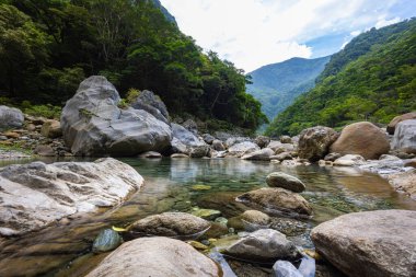 Taroko Ulusal Park Vadisi 'nden geçen bir derenin hayali fotoğrafı. İpeksi su, büyük taşların üzerine dökülür ve huzur verici bir manzara yaratır. Shakadang yürüyüş parkurunda, Tayvan doğal mucizeleri