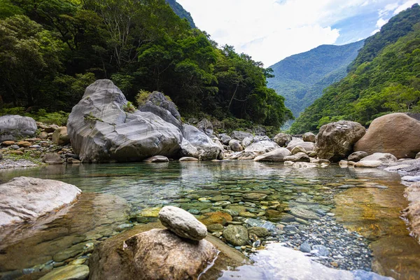 stock image Idyllic photo of a stream meandering through Taroko National Park valley. Silky water cascades over large stones, creating a serene scene. At the Shakadang hiking trail, Taiwan natural wonders