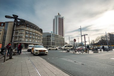 Leipzig, Almanya - 9 Şubat 2023: Wintergarten gökdeleni manzaralı Leipzig Merkez İstasyonu 'nda taksi durağı. Leipzig şehir merkezindeki en yüksek üçüncü bina. Taksi şoförü müşteri bekliyor.