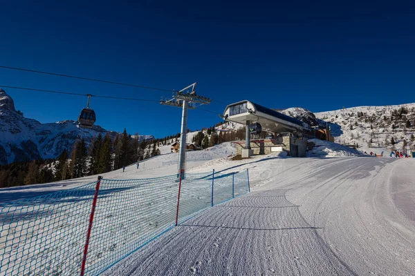 Dolomitler 'deki kar kaplı dağın nefes kesici manzarası, bir de teleferik. Uzaktaki görkemli zirveler karla örtülmüş. Zirveye doğru yükselir, ilham verici bir manzara sağlar.
