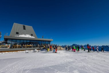 Falcade, İtalya - 15 Şubat 2023 Dolomitlerin dağlarındaki bir asansör istasyonunda. Kayakçılar teleferiği almak için sırada bekliyorlar. Kayakçı kuyruğu kayak merkezindeki asansöre kadar, bir sürü insan.