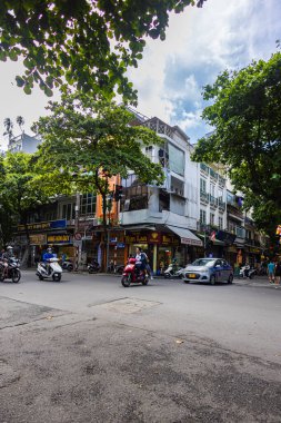 Hanoi, Vietnam - 28 Mayıs 2023: Büyüleyici Eski şehir sokakları canlı bir tablo ortaya koyuyor: motorlar ve bisikletler hızla geçiyor, melodik bir kakofoni yaratıyorlar. Bu enerjik sahne Vietnam kültürünü gözler önüne seriyor