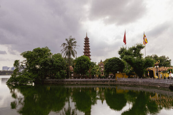 Hanoi, Vietnam - May 28, 2023: The Tran Quoc Pagoda, situated on a small island in Hanoi's West Lake, is an ancient Buddhist temple known for its rich history, tall slender stupa, and beautiful garden