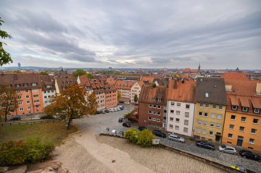 Nuremberg, Almanya - 25 Ekim 2023: Eski şehrin (Altstadt) çatıları üzerinde İmparatorluk Kalesi 'nden (Kaiserburg) görüntü. Şehrin üzerinde bulutlu bir gökyüzü. Bavyera şehrinin manzarası