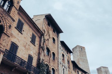 San Gimignano, Toskana, İtalya 'nın ortaçağ ev ve kulelerinin alçak açılı görüntüsü.
