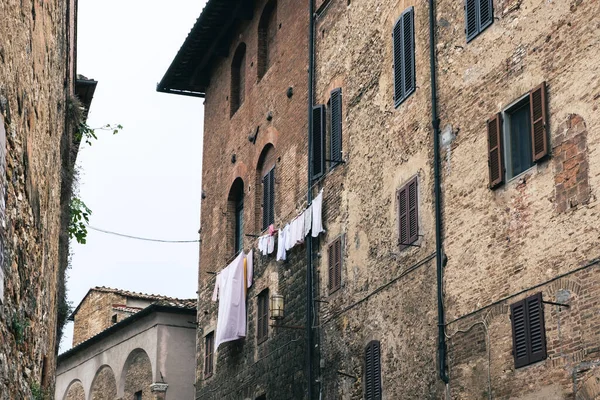 曇りの日にサンジミニャーノの古代の路地にぶら下がっている服 — ストック写真