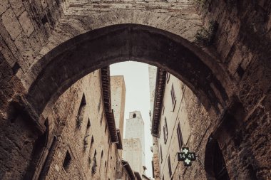 Bir ortaçağ kasabasının ara sokağındaki taş kemer görüntüsü. San Gimignano, Siena, Tuscany, kuzey-orta İtalya.