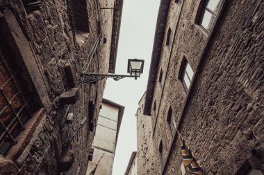 San Gimignano 'nun eski bir lambasının olduğu bir sokak. Siena, Toskana' da küçük bir ortaçağ kasabası. Güzel Kuleler Kasabası olarak bilinir..