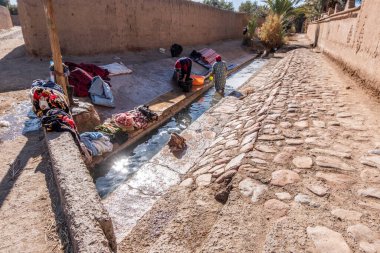 Women wash their clothes in the irrigation system that comes from the peaks of the High Atlas mountains in Morocco