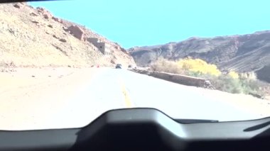View from the rear window of the car of the road through the Atlas mountains in Morocco towards the Sahara desert.