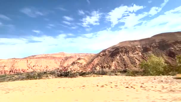 砂漠のパノラマとアトラス山脈を通ってモロッコのサハラに到着する途中の典型的な町 — ストック動画
