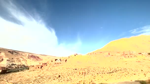砂漠のパノラマとアトラス山脈を通ってモロッコのサハラに到着する途中の典型的な町 — ストック動画