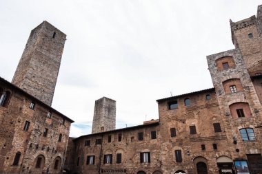Low angle view of the medieval buildings and a bell tower of a small village in the mountains in Tuscany