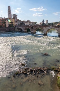 Shallow moving waters pass under an ancient bridge on the Adige river at Verona. Italy