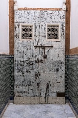 Ancient wooden door marked by time in a house with typical Moroccan ceramics. Marrakech