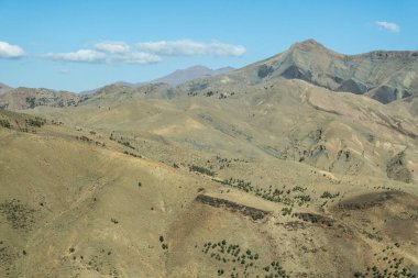 the road that crosses the Atlas mountains in Morocco reveals new wonders and surprises, from hidden valleys and sparkling streams to towering cliffs and soaring peaks that seem to touch the very sky.