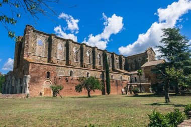 Panoramic view of san galgano abbey in Tuscany from the green garden in a sunny day with blue sky
