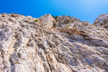 Irregular rock face with blue sky in the background on a beautiful warm sunny day in Santoniri. Greece