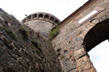 Muazzam duvarları ve asma köprüsü olan ortaçağ Toskana kalesi. San Gimignano, İtalya 'nın Tuscany eyaletinin Siena iline bağlı küçük bir ortaçağ kasabasıdır. Fine Kasabası olarak bilinir.