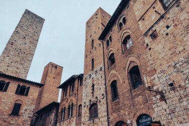 Muazzam duvarları ve asma köprüsü olan ortaçağ Toskana kalesi. San Gimignano, İtalya 'nın Tuscany eyaletinin Siena iline bağlı küçük bir ortaçağ kasabasıdır. Fine Kasabası olarak bilinir.