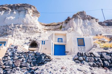 Yunanistan 'da Santorini' de bir plajda kayaya kaplanmış bir balıkçı evi.