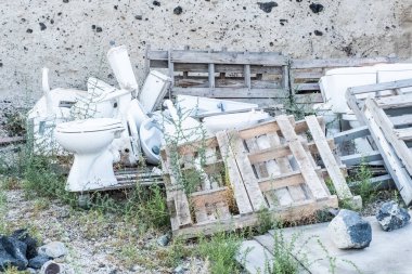 Rubbish and remains of abandoned buildings along the coast of santorini island in greece clipart