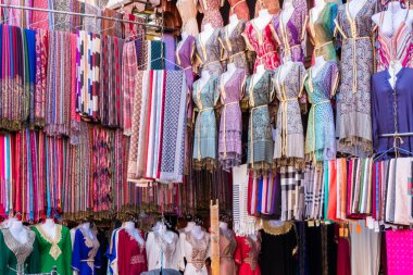 Renkli tipik Faslı kadınlar Marakeş Fas 'taki Jemaa el-Fnaa meydanı yakınlarındaki Medine' de bir çarşıda satılık elbiseler giyerler.