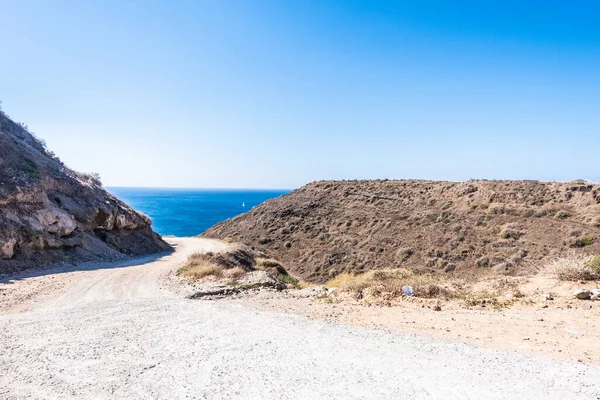 未舗装の道路はサントリーニ島の海につながります ギリシャ — ストック写真