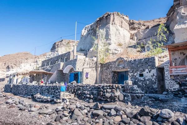 A fishermans house encrusted in the rock at a beach in santorini in greece