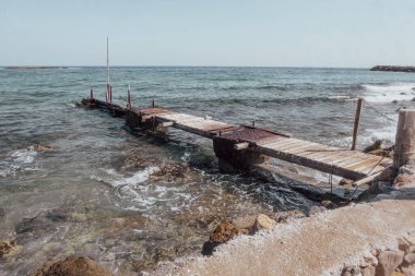 Zaman ve elementler tarafından giyilen bu eski iskele Girit Adası 'ndaki canlı Akdeniz dalgalarına çarpıcı bir tezat sunuyor..