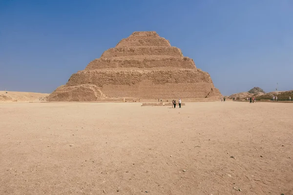 サッカラには 第3王朝時代に建てられた 歴史上最も古い完全な石造建築複合体 ドホーサーのピラミッドが含まれています サッカラピラミッド複合体が夕暮れとして神秘的なオーラを取るのを見る — ストック写真