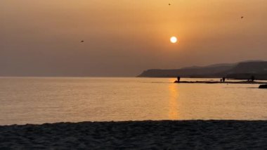 Sunrise Over calm Sea 'de Yunan Amforaları. Güneş sakin denizin üzerinden yükselirken, antik Yunan amforalarının bir koleksiyonu kıyı şeridini şereflendiriyor, zengin tarihi ve