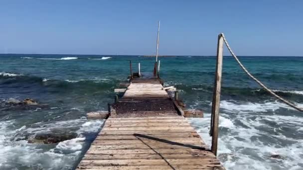 在希腊克里特岛 一个风吹日晒的木制码头与地中海无情的海浪相遇 见证了它的持久美丽 风吹日晒的木制码头和海浪 高质量的4K镜头 — 图库视频影像