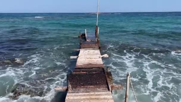 希腊克里特岛一个年久失修 饱受风吹日晒的码头 面对水晶般清澈的海水汹涌汹涌而屹立 这些长生不老的魅力与海洋的动能形成了鲜明对比 创造了 — 图库视频影像