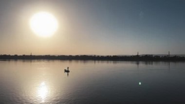 Nil Sunset Reverie: Balıkçı Ağı Ustası. Yüksek kalite 4K görüntü. Nil 'in altın sarılışında, yetenekli bir balıkçı ağını hazırlamakta ustalaşır. Bu sakin sahne kutluyor