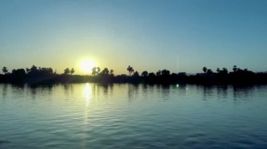 Gündoğumunda Nil 'e yelken açmak, Orman Sükuneti. Yüksek kalite 4K görüntü. Gün doğumunda Nil Nehri boyunca büyüleyici bir yolculuğa çıkın. Arkaplanınız huzurlu bir orman olsun. Bu büyülü an