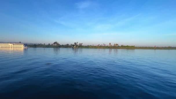 ナイル川で雄大なクルーズ船として魅惑的な遭遇が他の船によって優雅に通過するのを目撃します このシーンはエジプトの象徴的な水路に沿った賑やかな生活を反映しています ナイル川 — ストック動画
