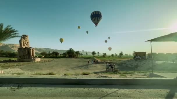 日出宁静 奢华的法老雕像和热气球 高质量的4K镜头 看到卢克索从你的车上升起的雄伟的日出 热气球在雄伟的巨石阵附近升起 — 图库视频影像