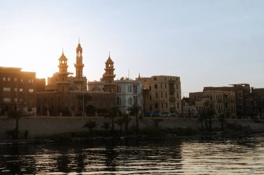 Luxor Limanı 'nın büyüleyici güzelliğini yaşayın. Şafağın ilk ışıkları Nil Nehri' ni altın renginde yıkarken. Bir yolcu gemisinin avantajlı noktasından, bu büyüleyici fotoğraf...
