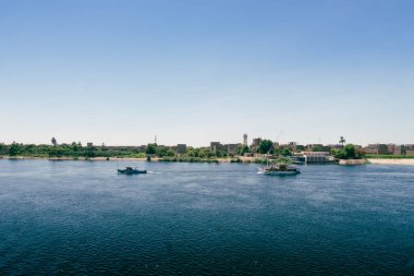 Mısır lüksünü bir Nil yolcu gemisinden Luxor limanının bu çarpıcı manzarasıyla tecrübe edin. Lüks seyahat dergileri ve üst düzey turizm içeriği için ideal. Mısır yaz cazibesini tecrübe eder.