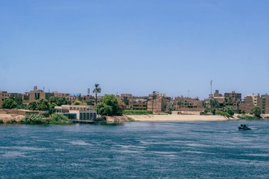 Mısır lüksünü bir Nil yolcu gemisinden Luxor limanının bu çarpıcı manzarasıyla tecrübe edin. Lüks seyahat dergileri ve üst düzey turizm içeriği için ideal. Mısır yaz cazibesini tecrübe eder.