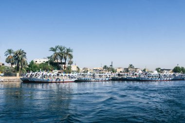 Nil Nehri 'nin sakin sularında yelken açarken kendini Luxor' un güzelliğine bırak. Bu nefes kesici fotoğraf, geleneksel Luxor 'un silueti tarafından çerçevelenmiş hareketli Luxor portunu yakalar.