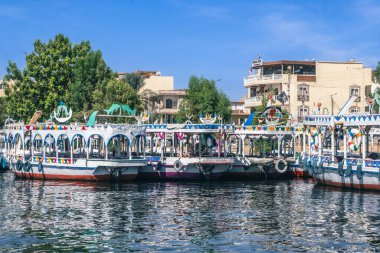 Nil Nehri 'nin sakin sularında yelken açarken kendini Luxor' un güzelliğine bırak. Bu nefes kesici fotoğraf, geleneksel Luxor 'un silueti tarafından çerçevelenmiş hareketli Luxor portunu yakalar.