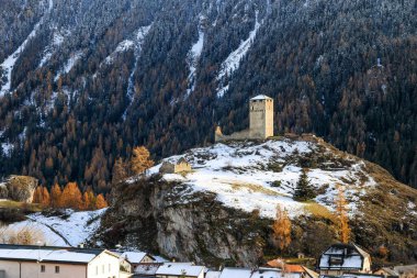 Eski Ortaçağ Şatosu 'ndan kalma kalıntılar İsviçre Alp Köyü Ardez' in üzerinde, Engadin Vadisi 'nde, Graubunden Kantonu' nun arka planında karlı dağ bulunuyor.