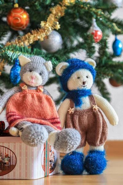 Self knitted kitty cat and teddy bear under the beautifully decorated Christmas tree