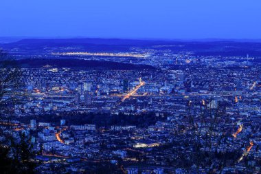 Swiss city Zrich in blue hours with the Zurich Airport at the far left above viewd from the Uetliberg