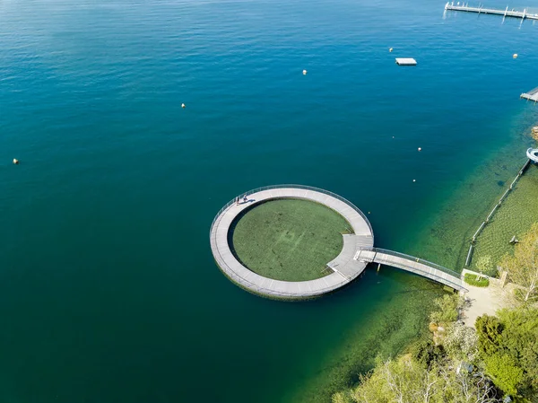 苏黎世湖边公共游泳池的空中图像 旁边有一个木制圆圆的幼儿池塘 图库图片