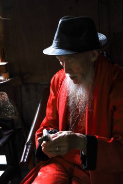 Chengdu, China - October 15. 2023: A senior is making pipes to sell in a local traditional teahouse in China