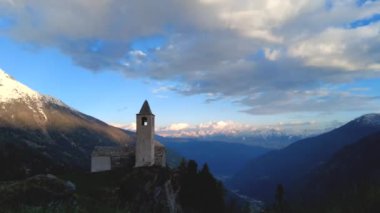 İsviçre 'deki Val Poschiavo vadisine bakan dağın tepesinde duran San Romerio şapeli.. 